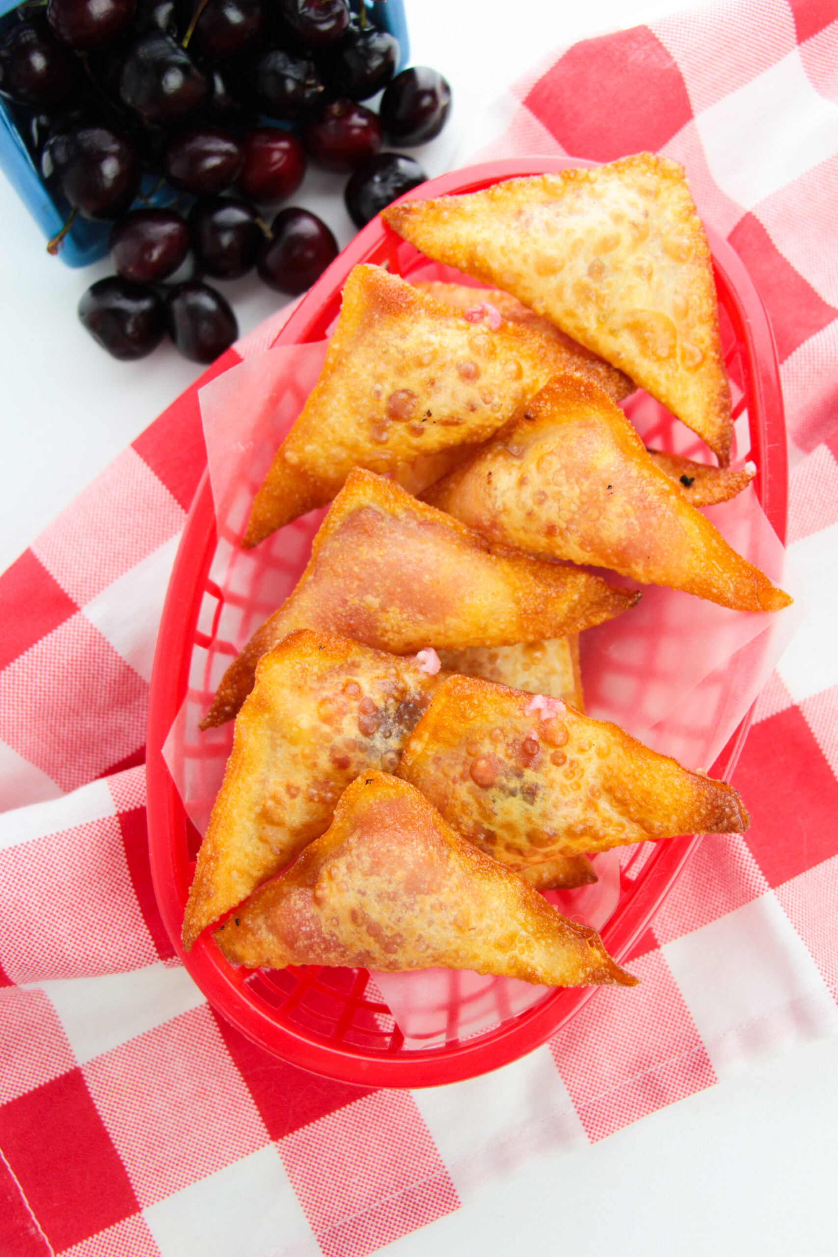 A red basket filled with the cherry cheesecake wontons.