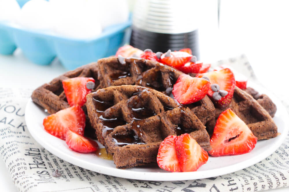 Chocolate Cake Waffles covered with strawberries and chocolate chips.