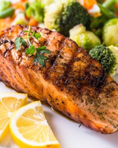 Grilled BBQ Salmon with a side of lemon and broccoli.
