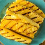 Grilled Pineapple Slices on a blue plate.