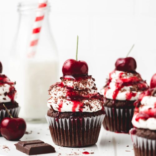 Three black forest cupcakes with cherries on top