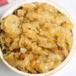 A bowl filled with Instant Pot Caramelized Onions, showcasing a golden-brown color and soft texture.