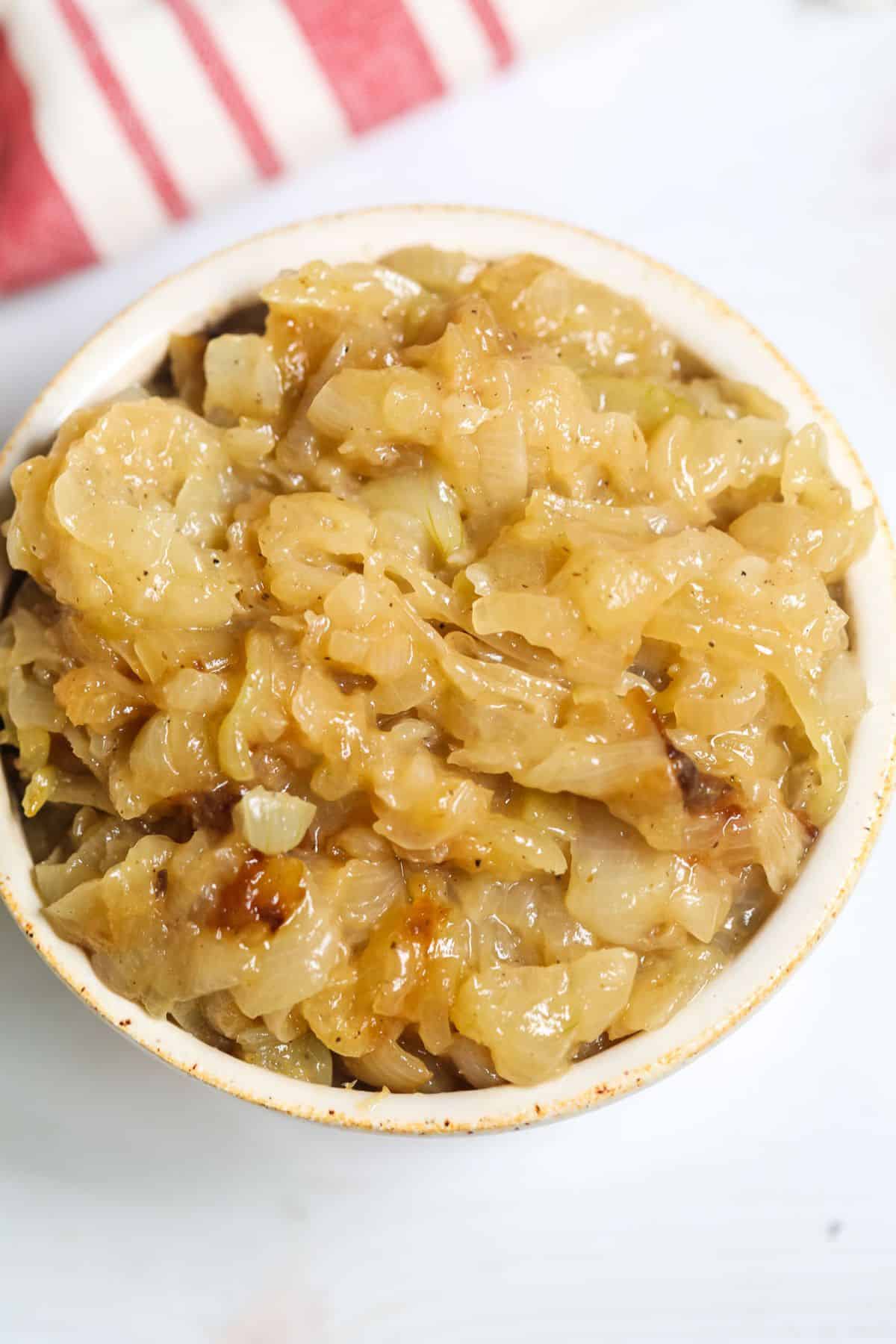 A bowl filled with Instant Pot Caramelized Onions, showcasing a golden-brown color and soft texture.