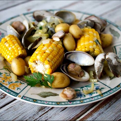 A plate filled with various grilled vegetables and clams