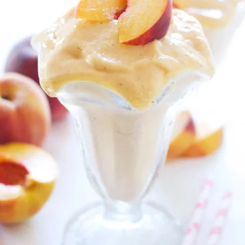 A Skinny Peach Milkshake garnished with peaches
