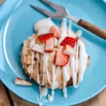 A strawberry scone on a blue plate with a fork.