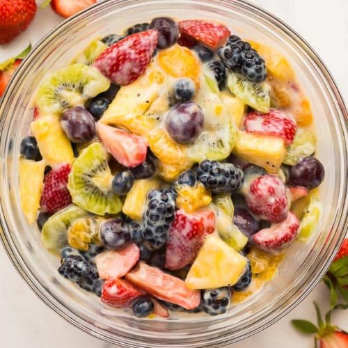 A bowl of fresh fruit drizzled in a creamy dressing
