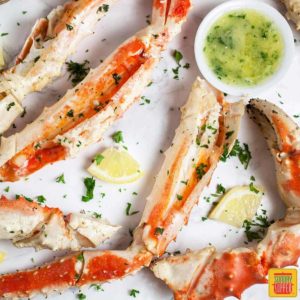 Several grilled crab legs with parsley as garnish