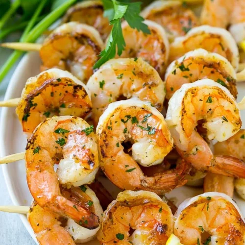 A plate with several shrimp skewers on it