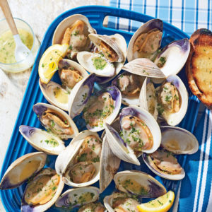 A plate of large clams with parsley and lemon