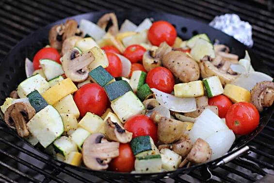 A pan of vegetables sits on a grill