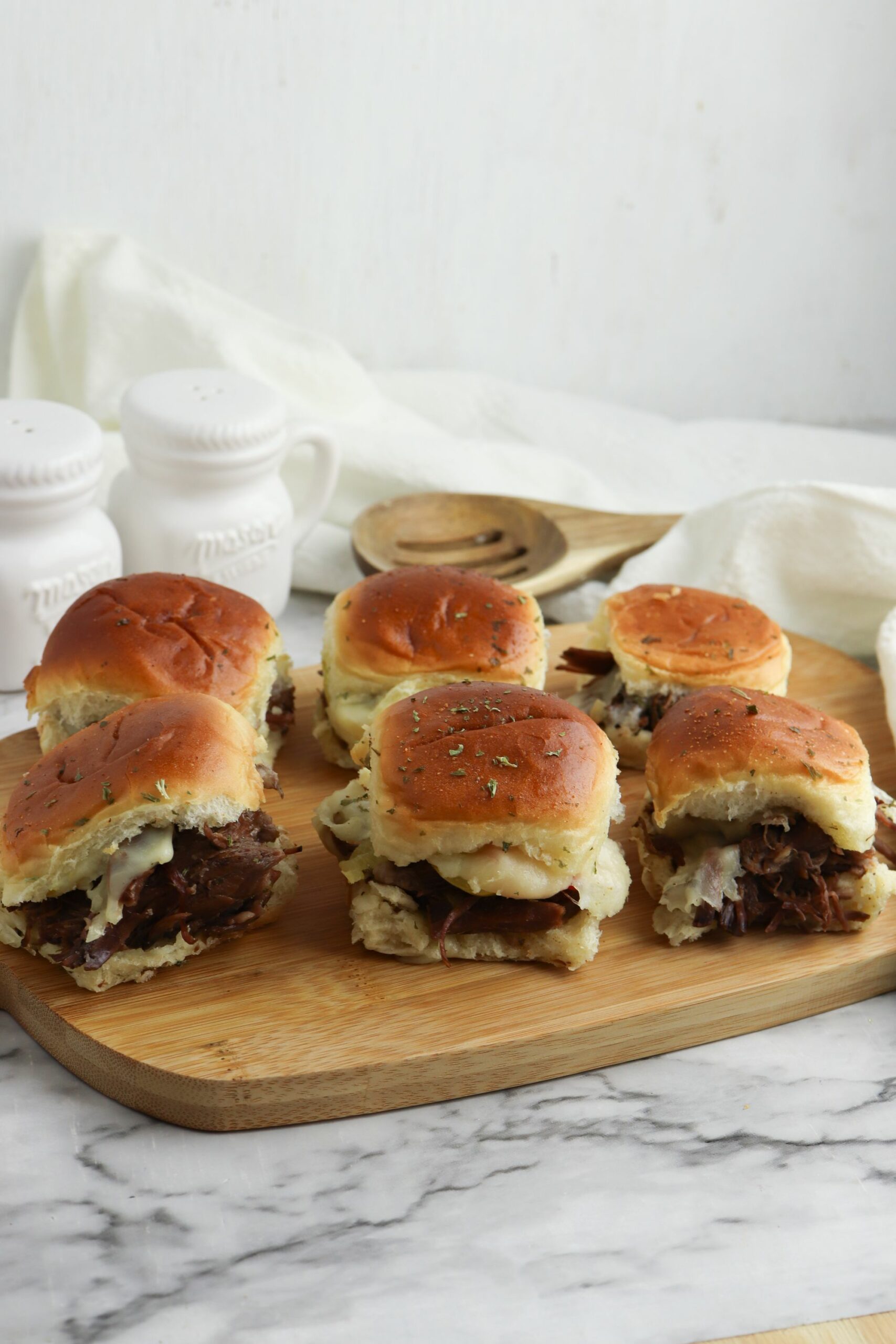 A cutting board full of the sliders.