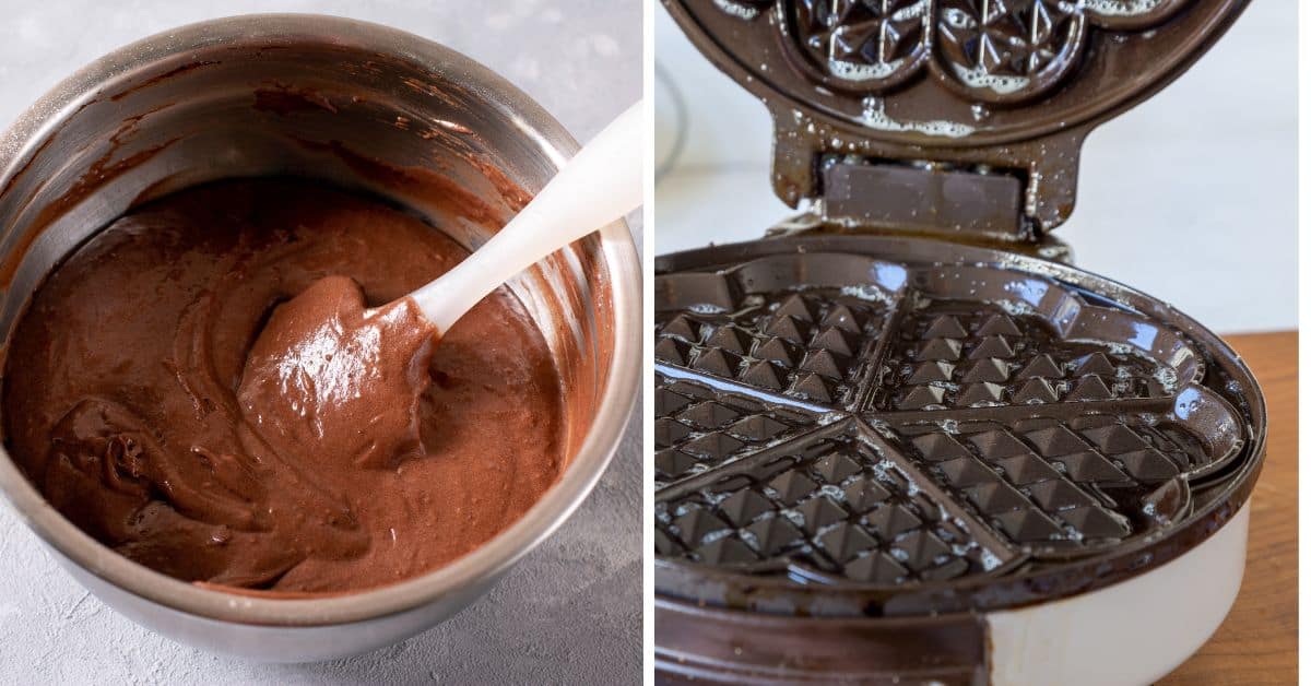 A bowl of chocolate batter, perfect for making Chocolate Waffles, sits with a spatula beside an open, greased waffle iron.