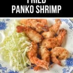 Plate of crispy panko shrimp served with shredded cabbage on a white and blue floral-patterned dish.