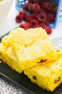 Lemon Blondies with Raspberries on a plate.