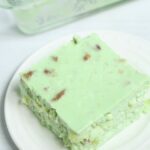 A square of lime jello salad on a plate.