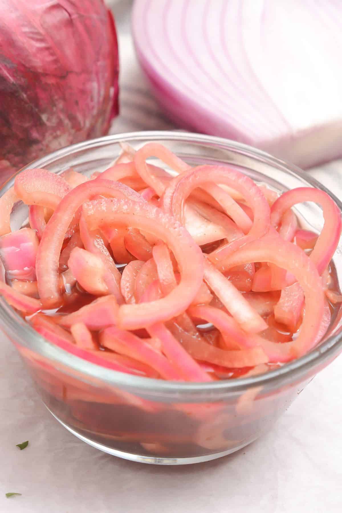 A glass bowl filled with vegetables in vinegar.