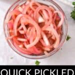 A glass bowl filled with vibrant Quick Pickled Onions sits on a white surface, with text below reading "Quick Pickled Onions.