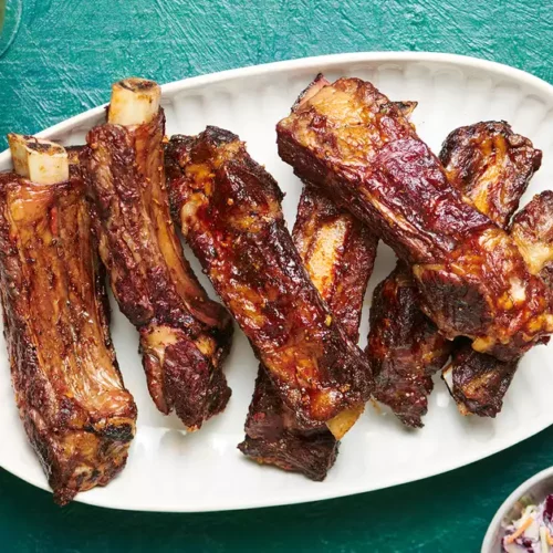 A plate has several grilled beef ribs