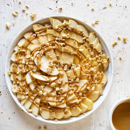 Apples in a bowl with peanut butter covered on top