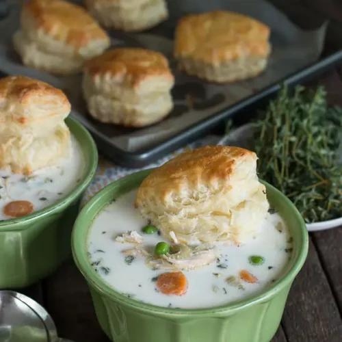 Chicken Pot Pie in a bowl with biscuits near