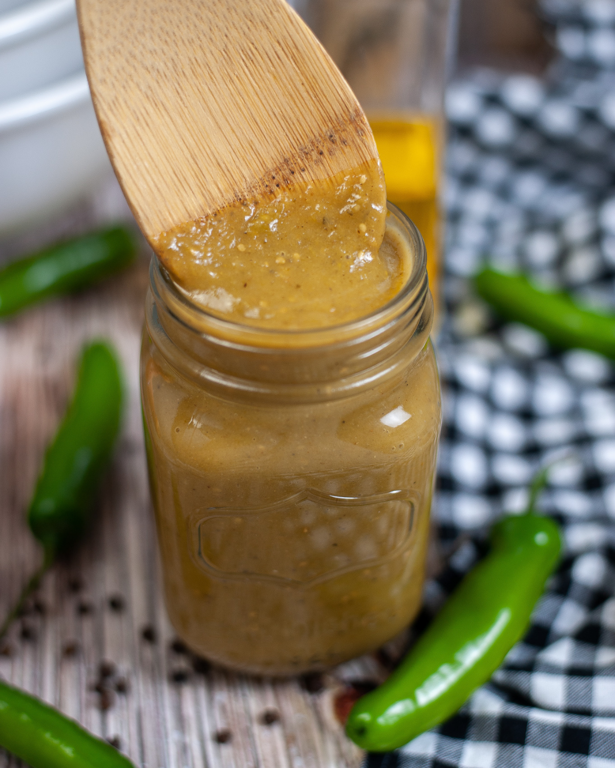 A jar of homemade sauce with a wooden spoon on top.