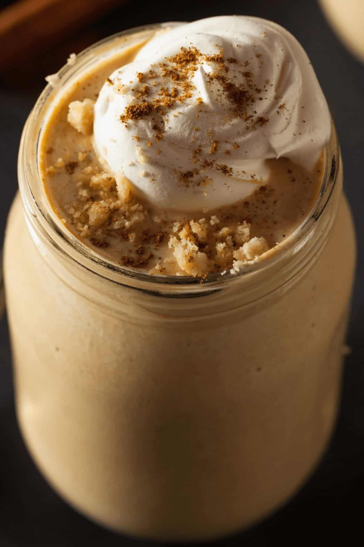 A top shot of the pumpkin milkshake with whip cream on top.