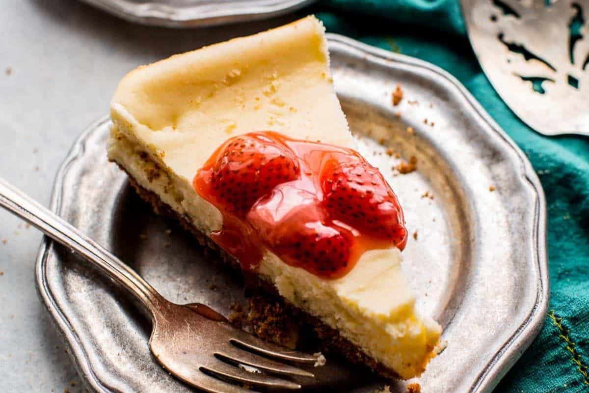 Mini cheesecakes with a creamy texture and graham cracker crust, each topped with a fruit garnish.