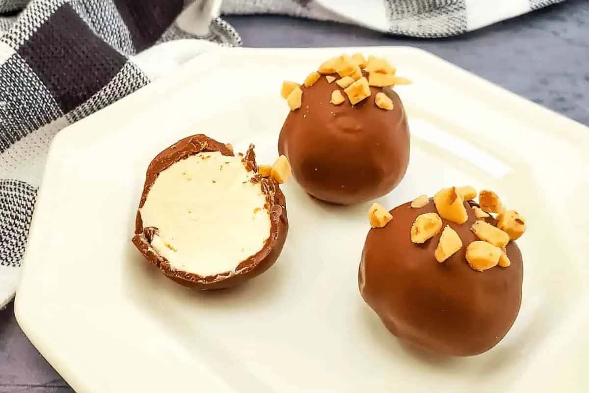 Bite-sized cheesecake balls coated in toffee bits, arranged on a serving tray.