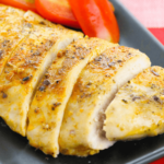 Baked chicken cutlets with tomatoes on a plate.