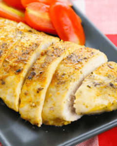 Baked chicken cutlets with tomatoes on a plate.