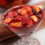 A clear dish of Cherry Jello Salad with Fruit.