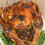 Slow Roasted Turkey with Herb Butter on a white platter.