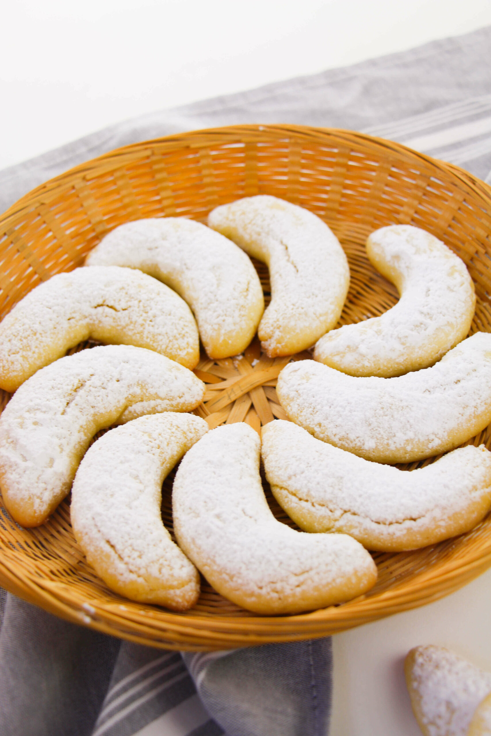 A wicker tray of almond crescent cookies.