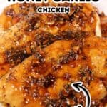 Close-up of Baked Honey Garlic Chicken breasts covered in a sticky honey garlic sauce, garnished with fresh herbs, on a white plate with text overlay reading "Baked Honey Garlic Chicken Delicious.