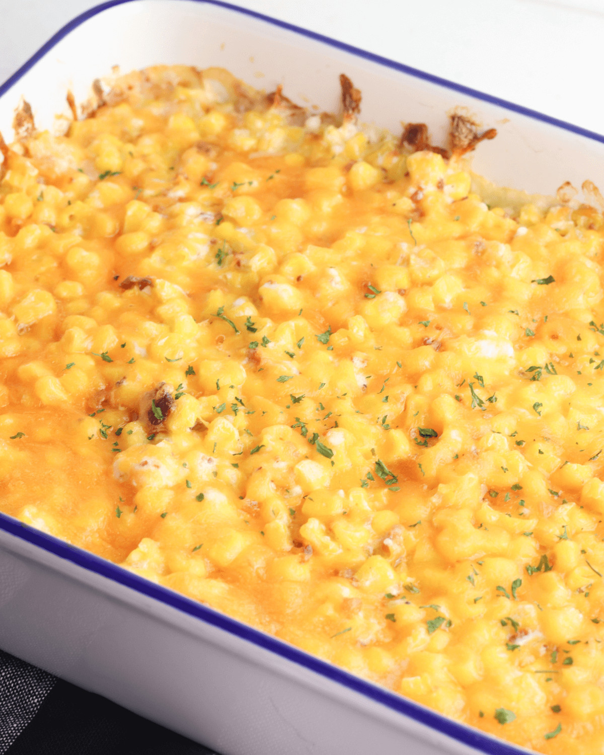 A baking dish with the cream cheese corn casserole with bacon.