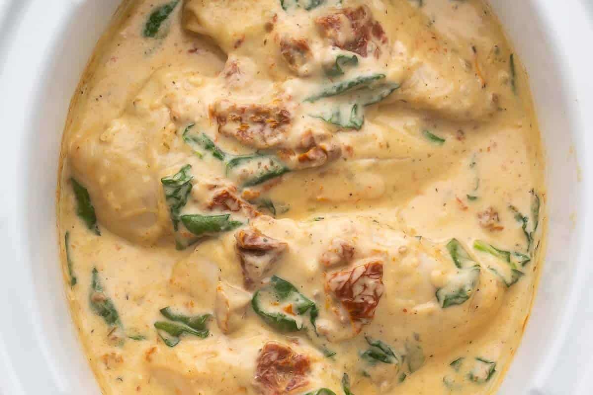 Chicken breasts in a creamy sauce with spinach and sun-dried tomatoes, perfect for slow cooking and ideal as new mom freezer meals.