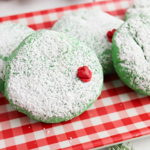 Grinch cookies on a red and white check napkin.