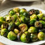 A white plate of Maple Roasted Brussel Sprouts.