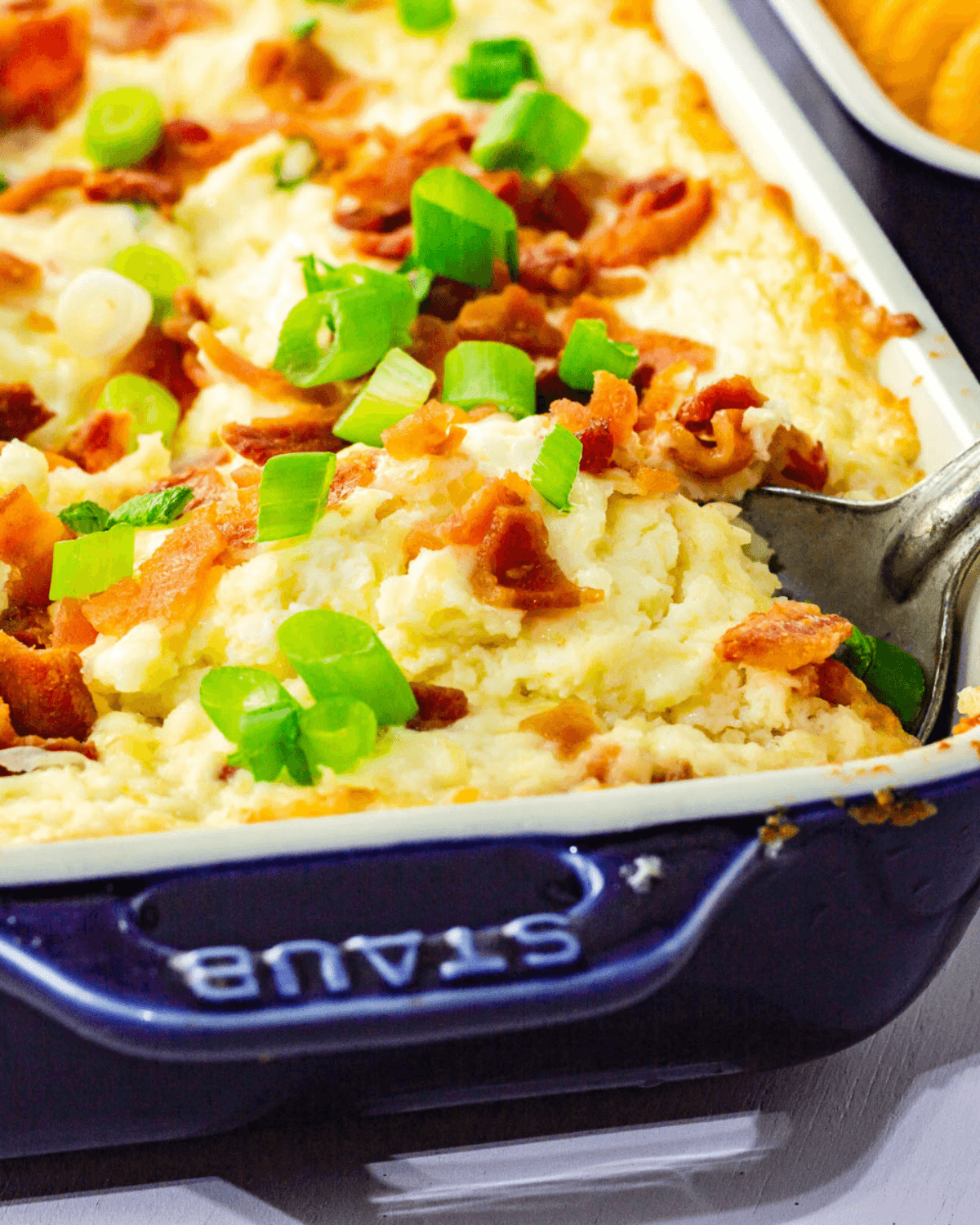 A baked cheese dip with bacon and green onions.