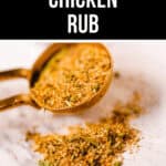 Image of a barbecue chicken rub for smoking, with a measuring spoon heaped with the spice mixture and some of the rub sprinkled below on a marble surface.