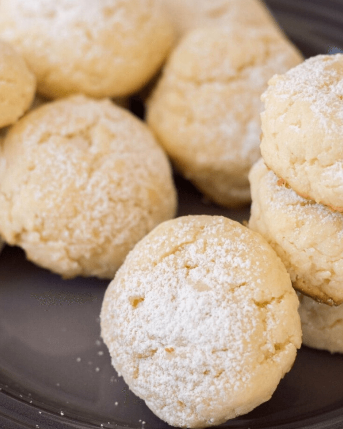 A closeup on the cheesecake cookie coated in powdered sugar.