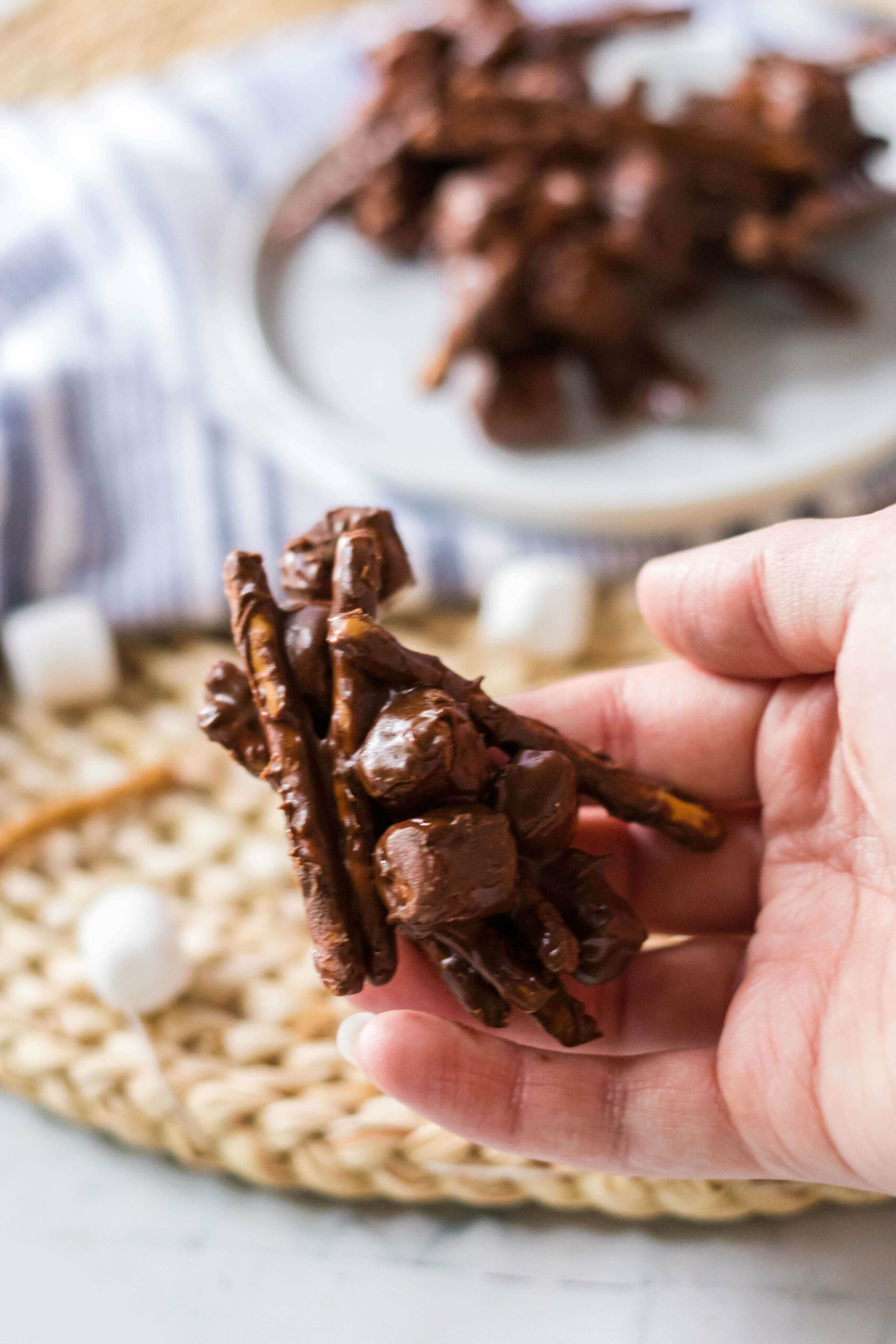 A hand holding the Chocolate Peanut Butter Haystacks.