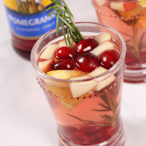 A Christmas Sangria with a sprig of rosemary in it.