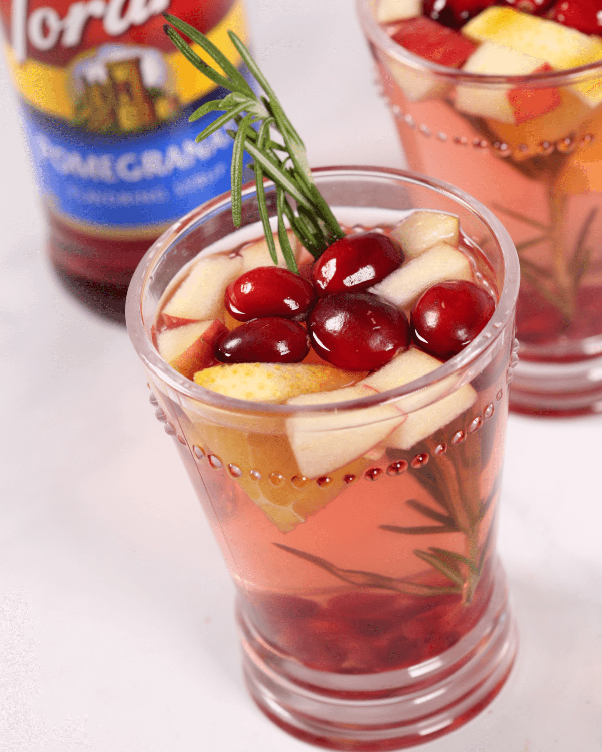A Christmas Sangria with a sprig of rosemary in it.