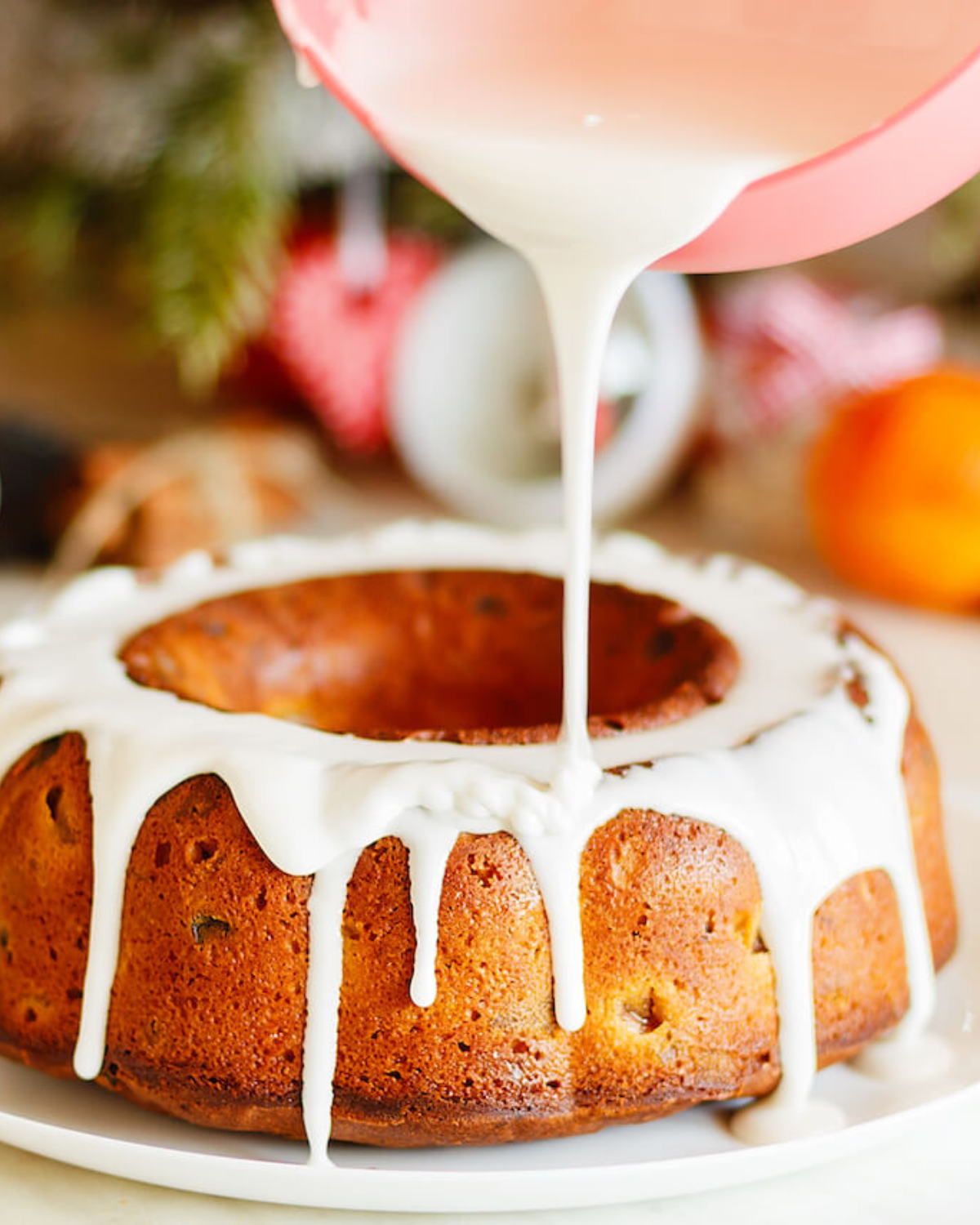 Drizzling the icing on top of the cinnamon bundt cake.