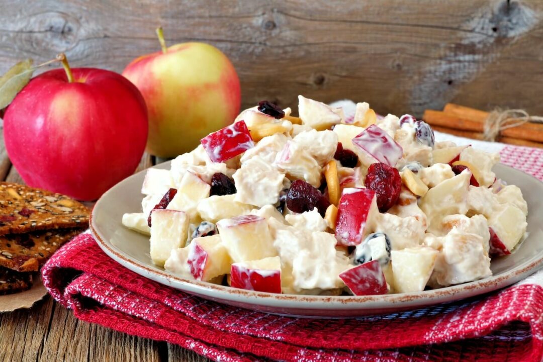 Cranberry Apple Salad on a plate with apples in the background.


