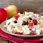 Cranberry Apple Salad on a plate with apples in the background.