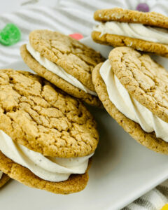 A white platter of the gingerbread sugar cookies with eggnog frosting.