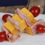 Cherry tomatoes and deli ingredients are elegantly placed on a white napkin.